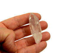 One raw clear quartz point 50mm on hand with white background