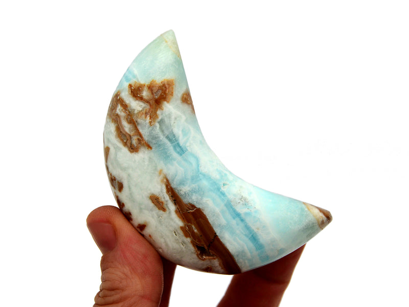 One caribbean calcite moon shapped stone 75mm on hand with white background