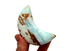 One caribbean calcite moon shapped stone 75mm on hand with white background