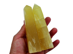 Two large lemon calcite tower 100mm on hand with white background
