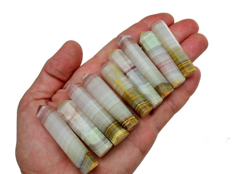 Nine pink banded onyx crystal towers 50mm on hand with white background