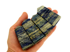 Four lapis lazuli crystal obelisks 60mm on hand with white background