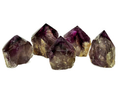 Four amethyst semi polished points 70mm-75mm on white background