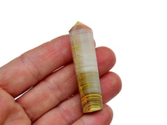 One pink banded onyx wand crystal 50mm on hand with white background