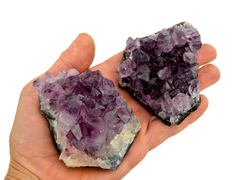 Two purple amethyst druzy crystals 70mm on hand with white background