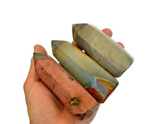 Three polychrome jasper points on hand with white background