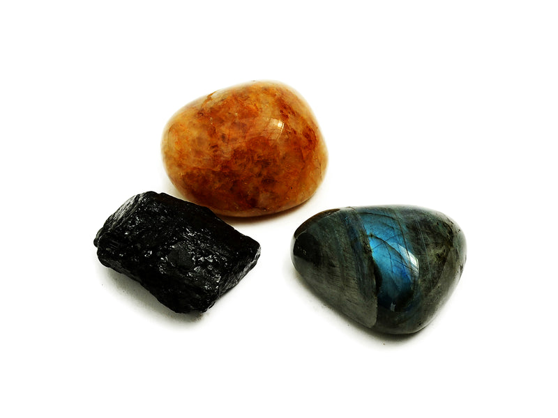 One labradorite tumbled stone, one hematoid quartz tumbled and one raw black tourmaline 50mm-60mm on white background