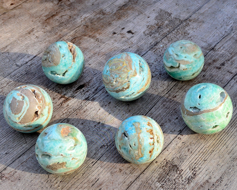 Some blue aragonite sphere stones 70mm on wood table