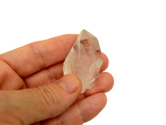 One raw clear quartz point 30mm on hand with white background
