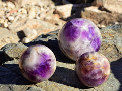 Three amethyst sphere stones 70mm - 95mm on natural rock