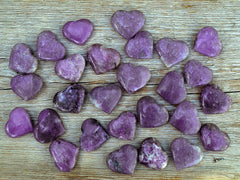 Several lepidolite heart stones 35mm - 40mm on wood table