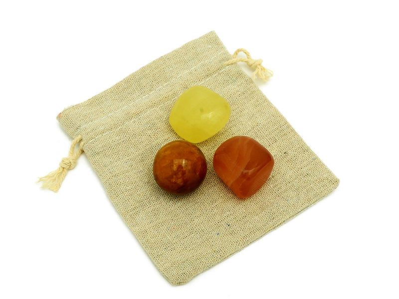Small lemon calcite and honey calcite tumbled with golden healer quartz sphere on small bag