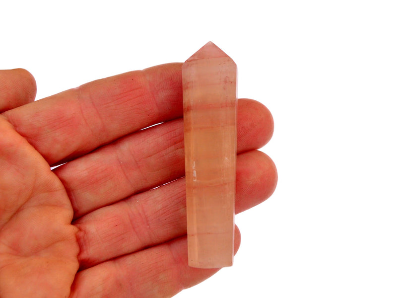 One rose calcite tower crystal 55mm on hand with white background