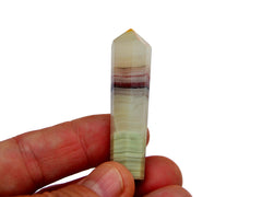 One pink banded onyx tower crystal 50mm on hand with white background