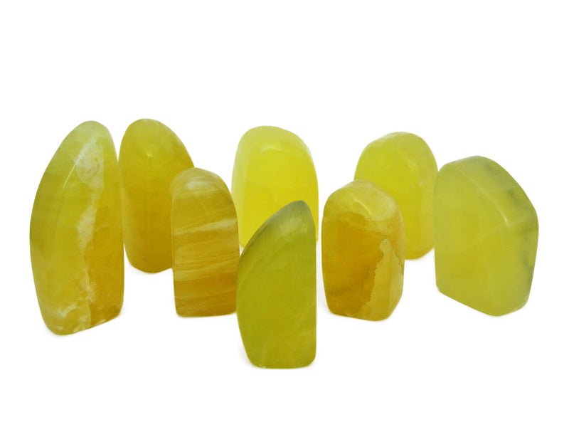 Some yellow calcite free form stones on white background