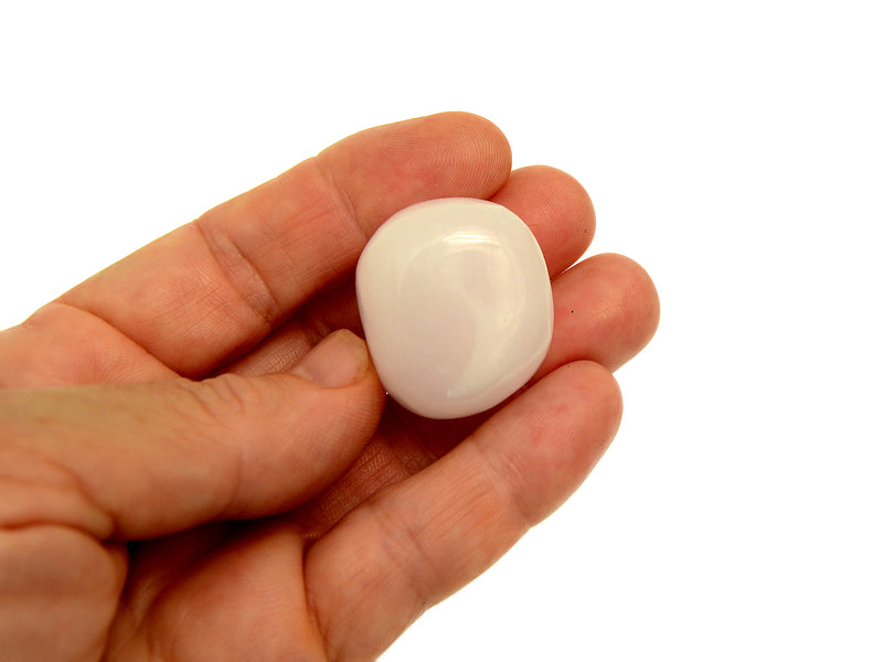Pink mangano calcite tumbled stone 20mm on hand with white background
