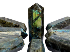 One chunky flashy labradorite obelisk 110mm on hand with background with some towers on white