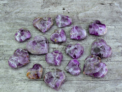 Several chevron amethyst heart stones 50mm-80mm on wood table
