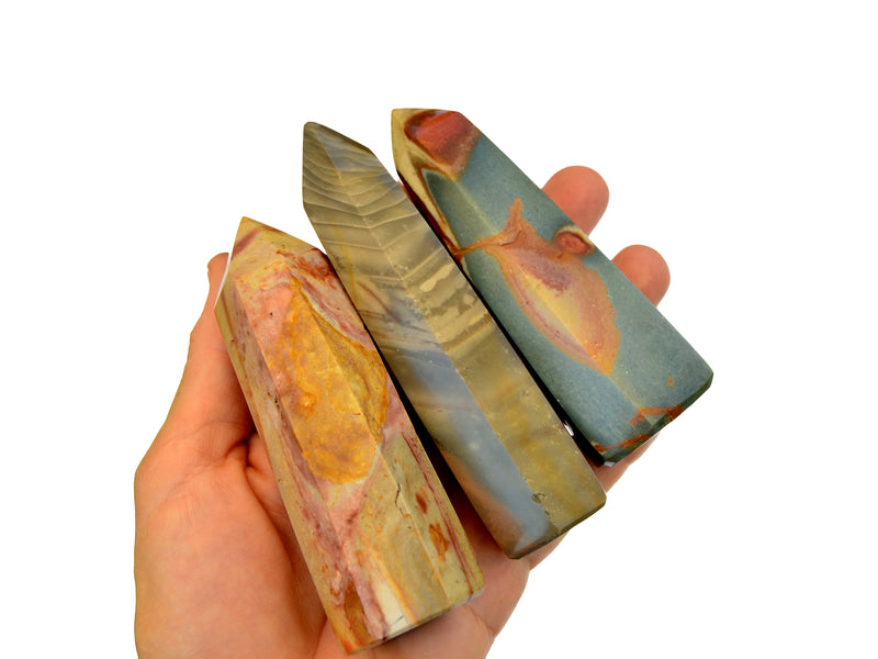 Three polychrome jasper crystal points on hand with white background