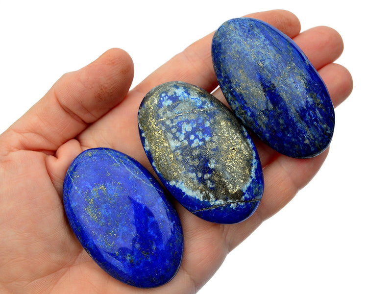 Three lapis lazuli palm stones 70mm on hand with white background