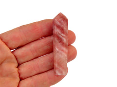 One pink calcite crystal point 65mm on hand with white background