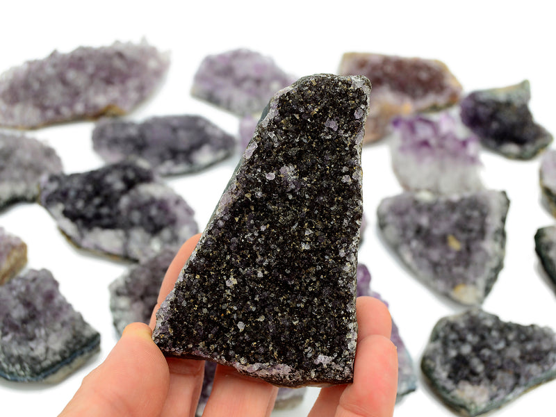 One druzy amethyst stone 100mm on hand with background with some crystals on white