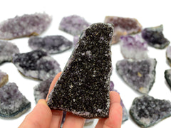 One druzy amethyst stone 100mm on hand with background with some crystals on white