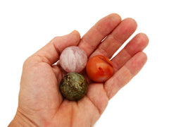 Carnelian, rose quartz and chrysocolla sphere crystals 30mm on hand with white background