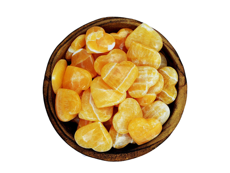 Several orange calcite crystal hearts 30mm-35mm inside a wood bowl on white background