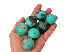 Small amazonite spheres 25mm-40mm on hand wit white background