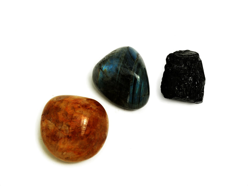 One golden healer quartz tumbled, one labradorite tumbled and raw black tourmaline 50mm-60mm on white background