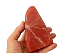 One large rose calcite free form crystal 110mm on hand with white background