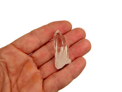 One mini rock crystal cluster on hand with white background