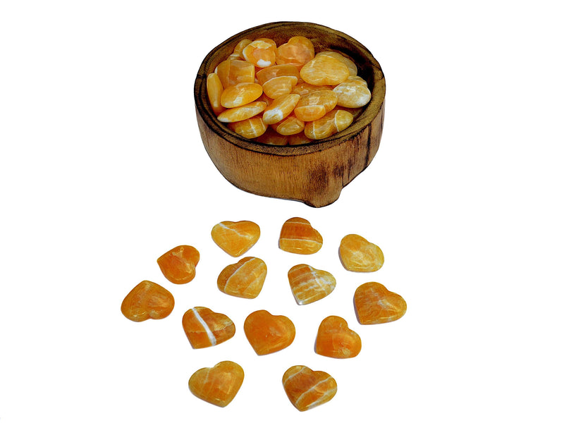 Several small orange calcite small hearts 30mm-35mm inside a wood bowl with background with some hearts on white