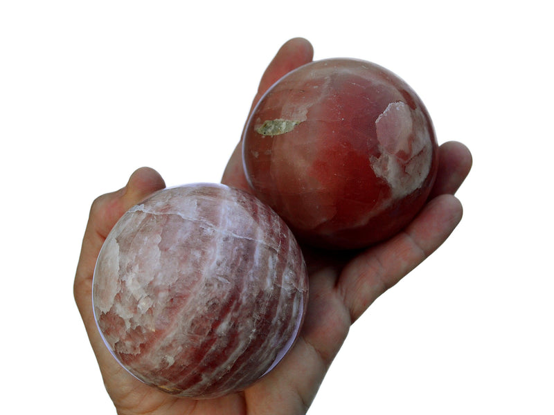 Two rose calcite sphere stones 65mm-70mm on hand with white background