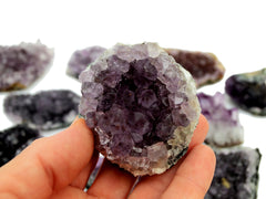 One natural amethyst druzy stone 80mm on hand with background with some clusters on white
