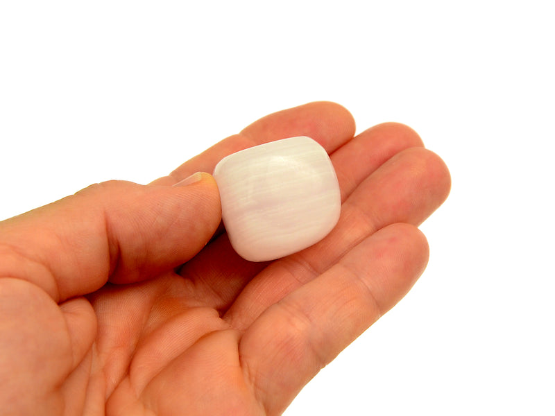 Mangano calcite cubic tumbled stone 30mm on hand with white background