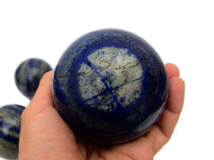 One lapis lazuli sphere stone 85mm on hand with white background