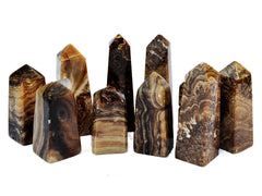 Some chocolate calcite obelisk crystals different sizes on white background