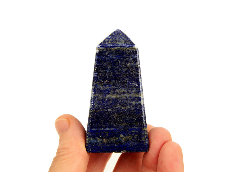 One blue lapis lazuli obelisk crystal 70mm on hand with white background