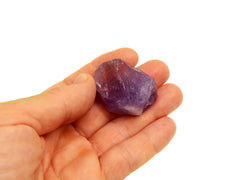 Raw purple amethyst stone 30mm on hand with white background