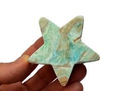 One blue aragonite star carving crystal 60mm on hand with white background