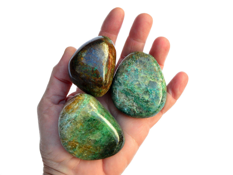 Three big green chrysocolla tumbled stones on hand with white background