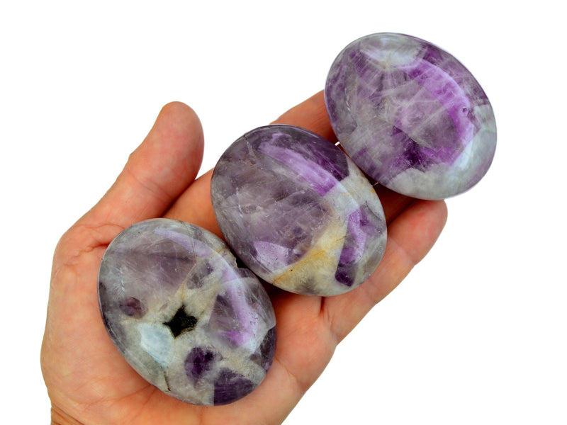 Three amethyst palmstone crystals 50mm on hand with white background