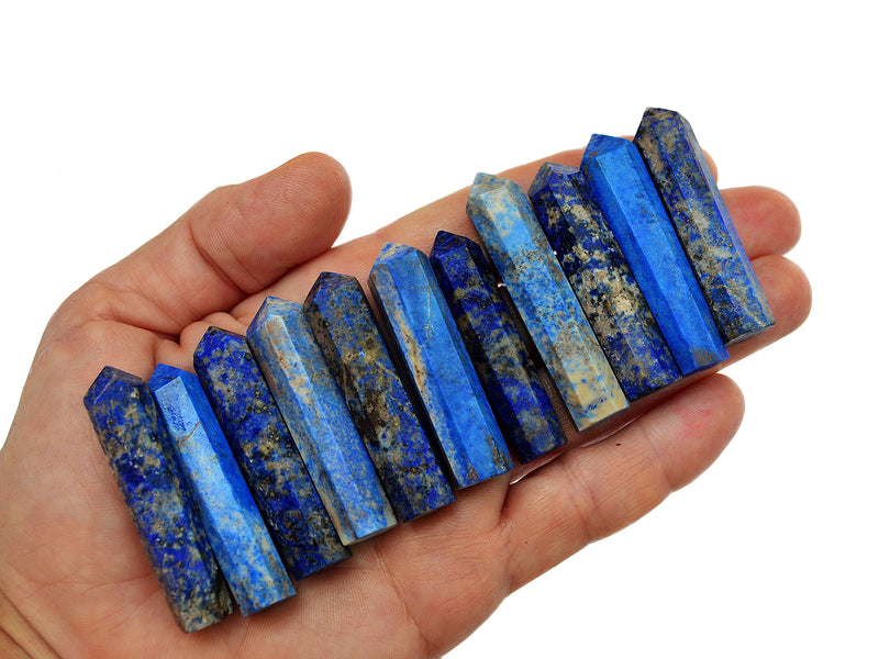 Eleven lapis lazuli faceted tower crystals 40mm-50mm on hand with white background