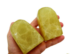 Two big lemon calcite free form stones 90mm on hand with white background