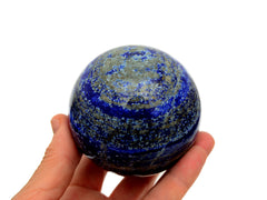 Lapis lazuli sphere crystal 65mm on hand with white background