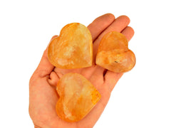 Three goden healer quartz heart crystals 50mm-55mm on hand with white background