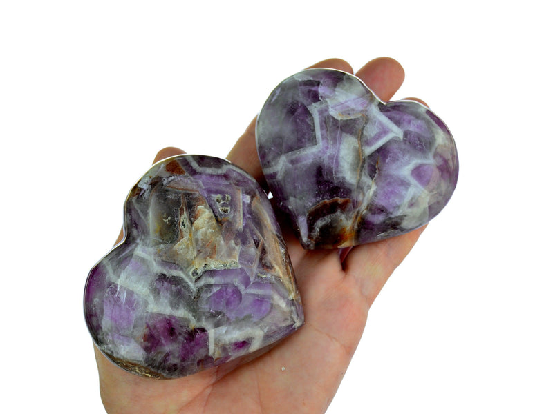Two amethyst quartz stone hearts 70mm on hand with white background