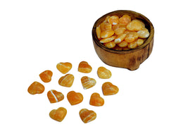 Several orange calcite small hearts 30mm-35mm inside a wood bowl with background with some hearts on white